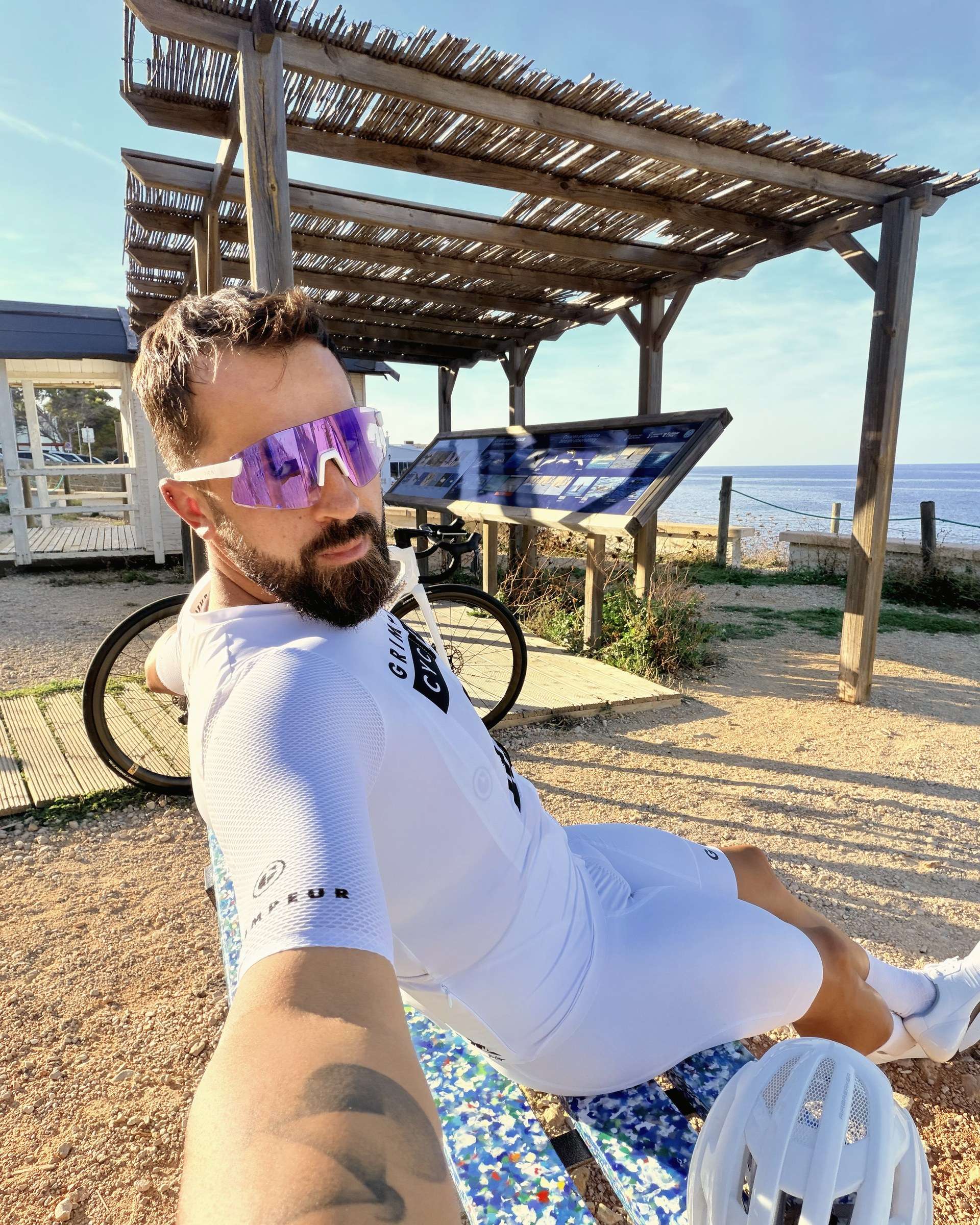 Kamil, le mécanicien de Plan B Cycling, avec son vélo pendant une pause au bord de la mer